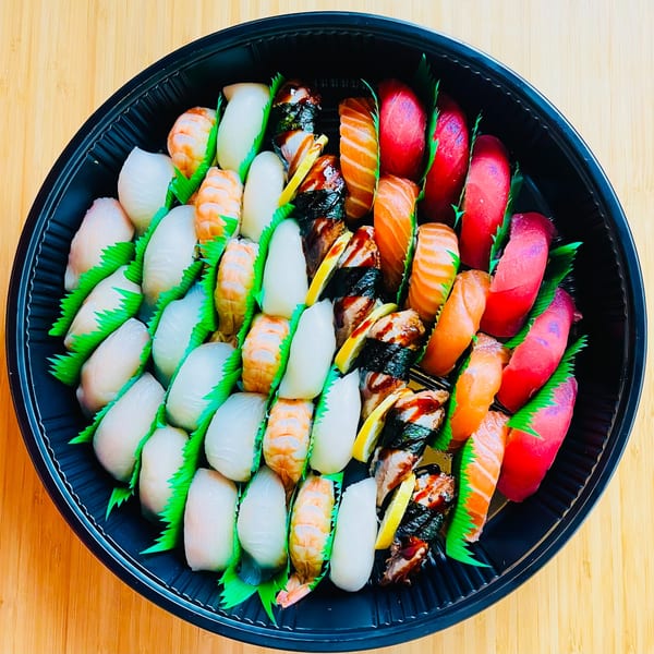 A large platter of Awi Sushi nigiri, including tuna, salmon, shrimp, and white fish.