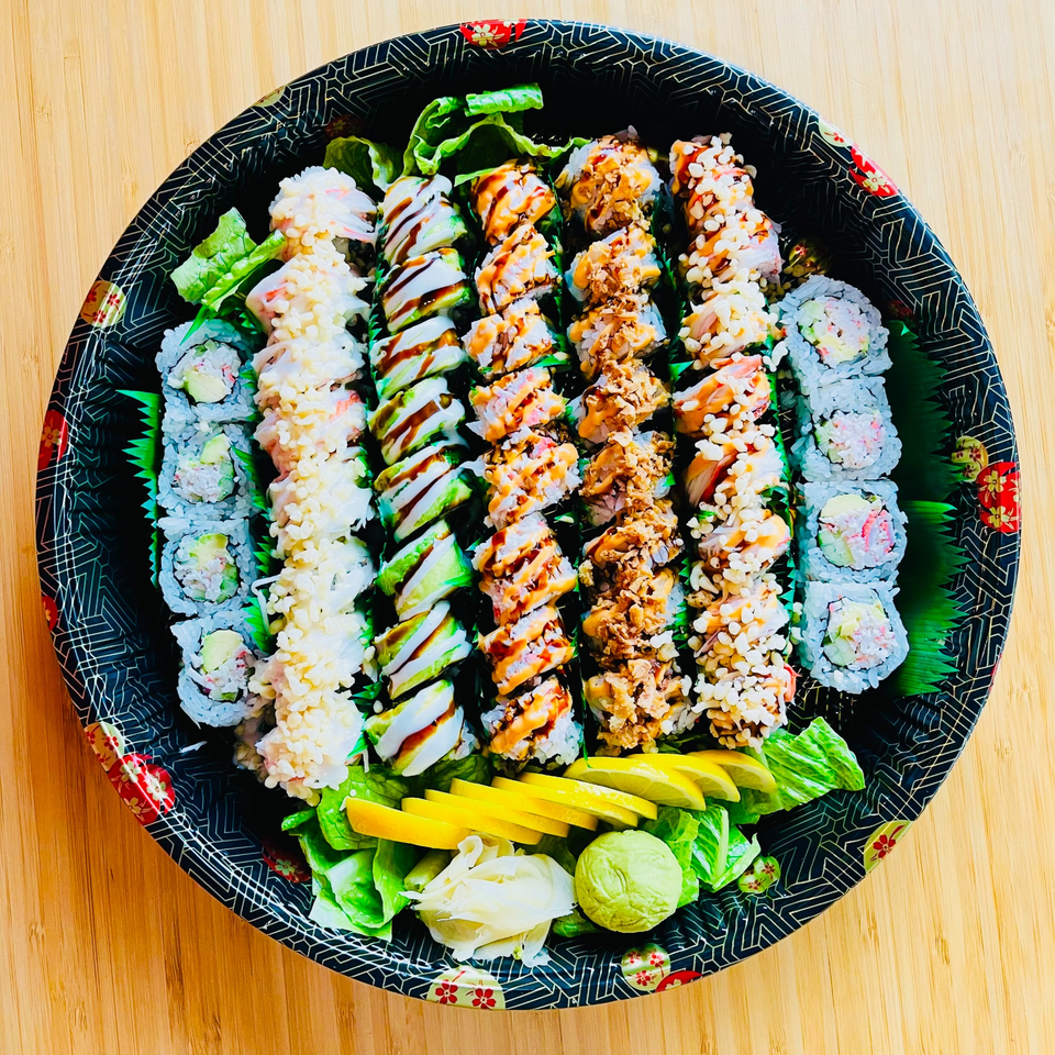 A large platter of assorted Awi Sushi rolls, including California, avocado, and crunchy rolls.